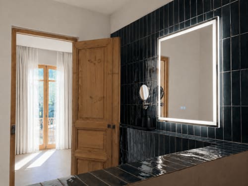 Modern bathroom at Le Palmier Aigues-Mortes with illuminated mirror and black tile walls