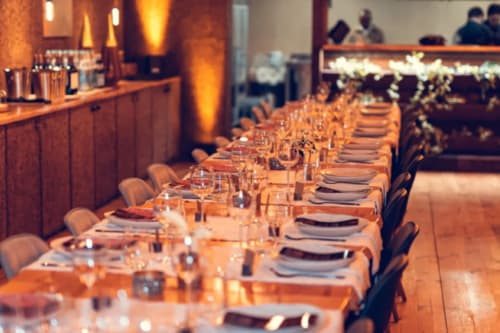 Elegant dining setup at Charm Nature B&B in Azóia, Portugal with long table, place settings, and warm ambient lighting