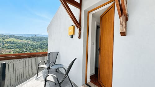 Terraço privado com assentos no quarto deluxe da Quinta das Susandas com vista para as colinas do interior português