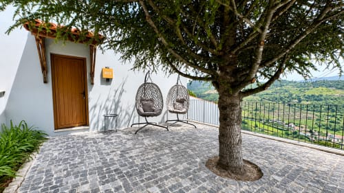 Quarto deluxe com varanda na Quinta das Susandas, cadeiras suspensas, árvore frondosa, vista para o campo, Portugal