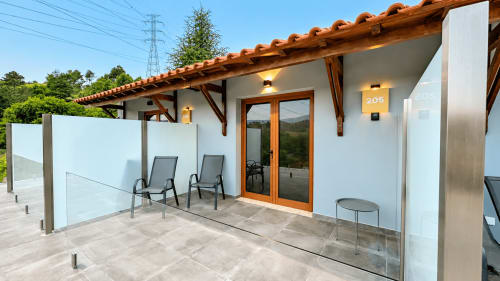 Suíte Deluxe 205 com terraço privado na Quinta das Susandas: espreguiçadeiras, guarda-corpo de vidro e vistas para a montanha