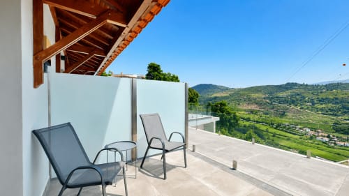 Terraço do quarto deluxo da Quinta das Susandas com espreguiçadeiras e vista para o vale de Tresouras, Portugal
