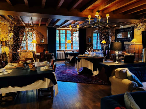 Elegant dining room at La Domerie B&B in Saint-Chély-d'Aubrac with warm lighting, ivy-covered walls, and upscale table