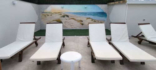 Zona de descanso junto a la playa del Hotel Paraiso Playa en Isla Cristina con tumbonas blancas, murales y vistas al mar