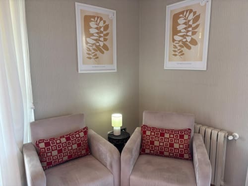 Acogedor rincón de estar en cottage Mar y Sol, Baiona con dos sillones rosas, cojines estampados rojos y arte botánico en la pared