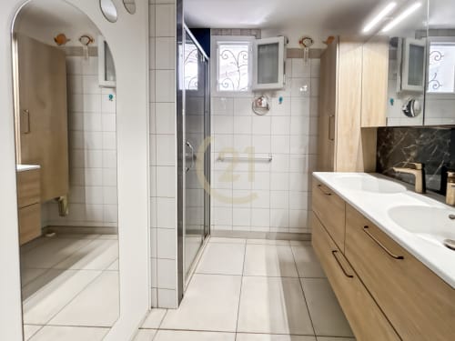 Salle de bains moderne dans une villa corse avec double vasque, douche à l'italienne et meuble en bois clair