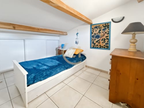 Chambre lumineuse avec literie bleue, poutres et mobilier en bois à la Villa Marine de Sant Ambroggio, L'Île-Rousse