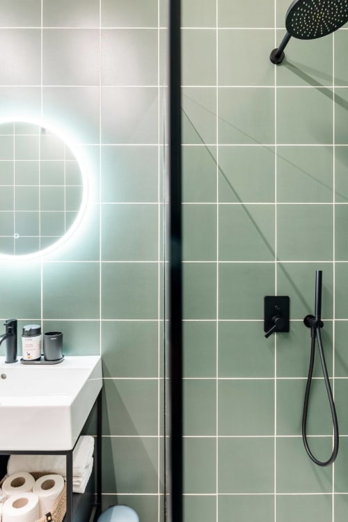 Bagno moderno con doccia rivestita in piastrelle verde salvia, rubinetteria nera e specchio illuminato presso Camere d'Aria B&B a Locana