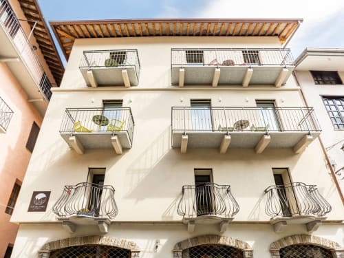 Facciata del Camere d'Aria a Locana con balconate, vedute panoramiche, finestre ad arco e ringhiere metalliche moderne