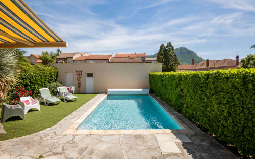 Private pool villa in Millau with turquoise heated pool, lounge chairs, manicured lawn and mountain views