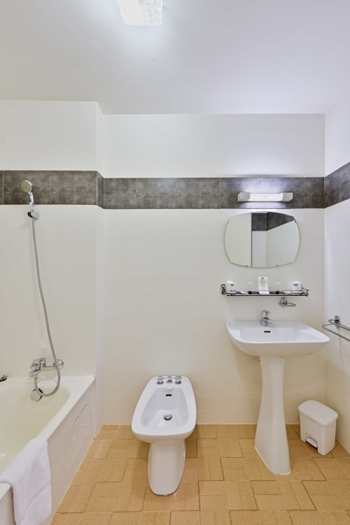 Salle de bain avec bidet, lavabo sur piédestal, baignoire et douche à l'Hôtel Restaurant Le Verdon, Les Salles sur Verdon