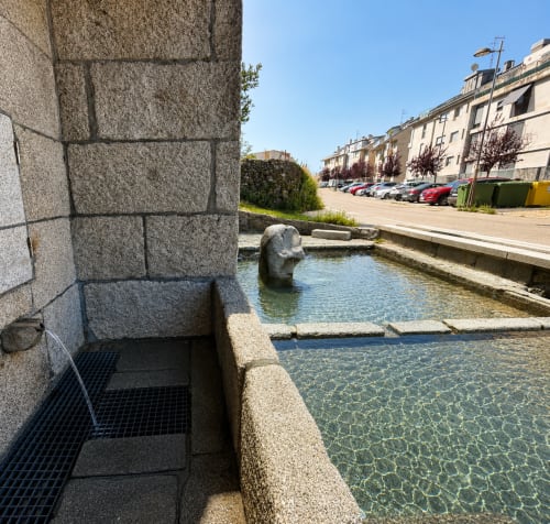 Piscina con bordes de piedra y agua cristalina en el apartamento Afouteza de Baiona, España, con vistas al aparcamiento