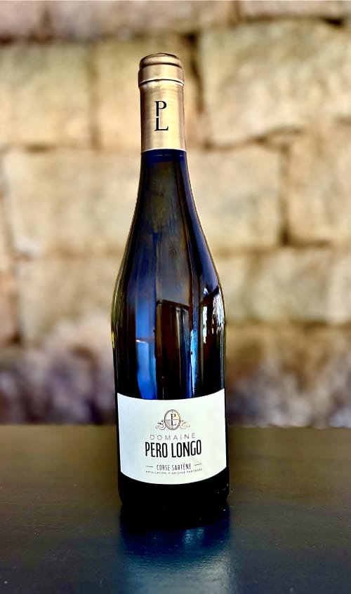 Bouteille de vin Domaine Pero Longo Saryene Corse présentée dans une maison d'hôtes luxueuse à Sartène
