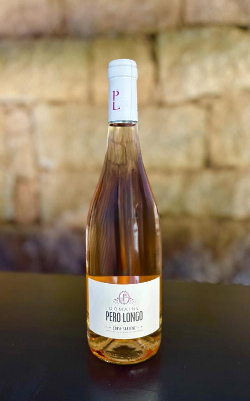 Bouteille de vin rosé Domaine Pero Longo Corse Sartène devant un mur de pierre