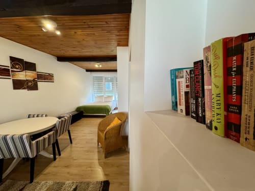 Chambre douillette avec bibliothèque, coin repas et lit au Gîte du Cœur du Village Verniolle en Ariège