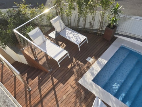 Vista aérea do deck da villa Casa Cliff com espreguiçadeiras, piscina privada e telas de bambu em Sesimbra