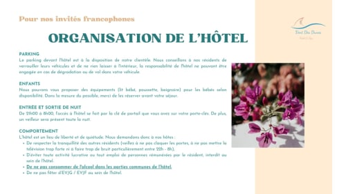 Vent Des Dunes hotel rules in French: parking, children amenities, check-in/out times, conduct policy with purple flowers