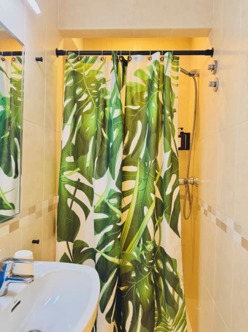 Bagno moderno all'ostello Nanit Rooms Ibiza con tenda doccia a foglie tropicali e piastrelle gialle