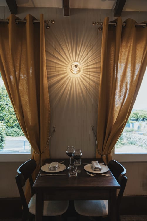 Élégante mise de table au Savoy Hôtel avec rideaux dorés, couverts dressés et lustre rayonnant.