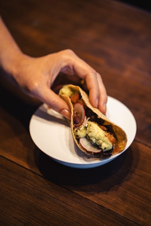 Main tenant un taco gastronomique aux fruits de mer au Savoy Hôtel Le Bourget-du-Lac