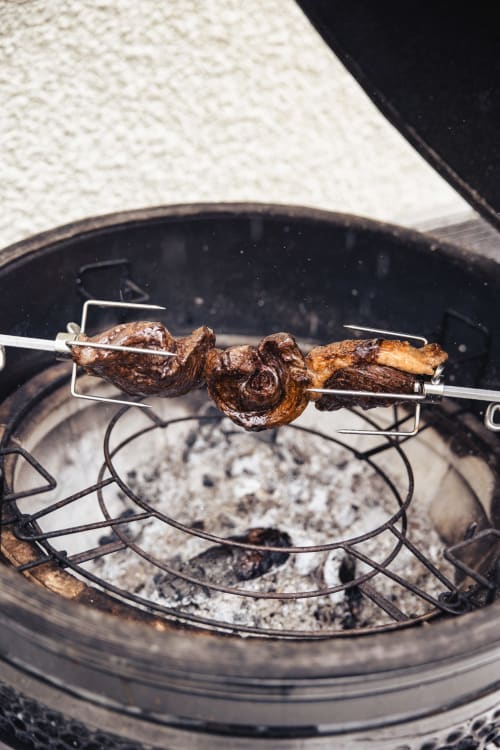 Brochette de viande grillée cuisant sur les braises dans une poêle en fonte au Savoy Hôtel Le Bourget-du-Lac