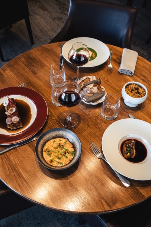 Table de restaurant gastronomique au Savoy Hôtel avec plats raffinés, verres de vin et assiettes dressées