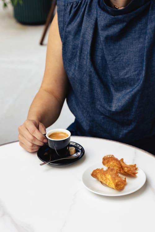 Client du Savoy Hôtel dégustant un espresso et des pâtisseries à la terrasse d'un café au Bourget-du-Lac