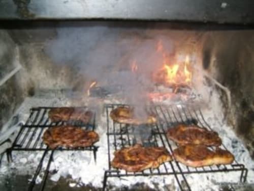 Filetes de carne a la parrilla cocinándose al fuego abierto en el Hotel Llibrada de Benasque, España