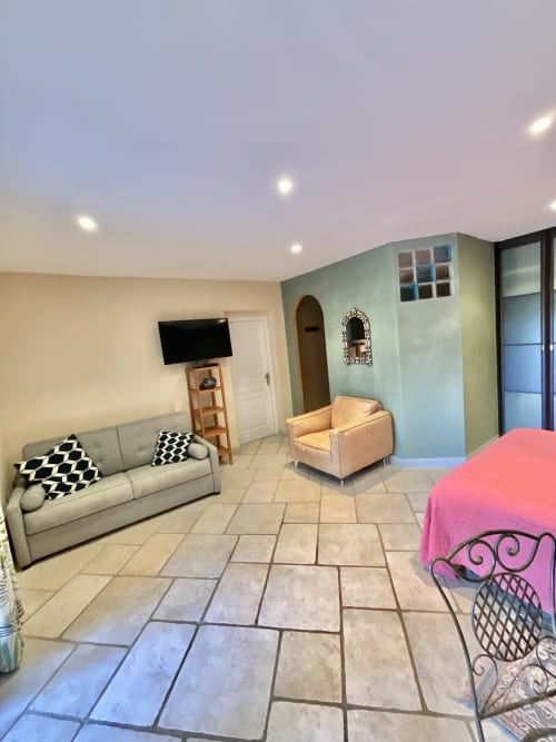 Chambre spacieuse au Domaine Pero Longo à Sartène avec coin salon, télévision et vue sur le jardin