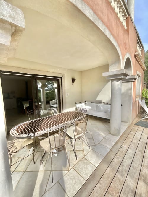 Terrasse ensoleillée du Domaine Pero Longo avec table à manger, lit de jour et accès intérieur à Sartène