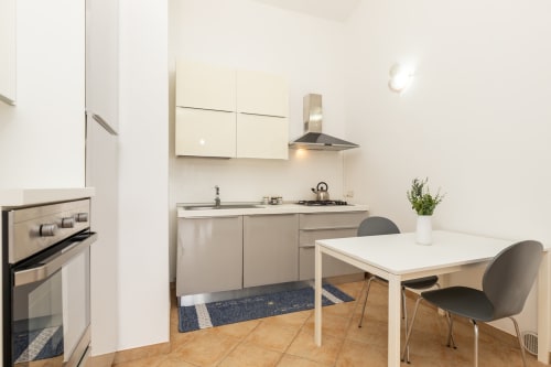 Modern kitchen with dining area at Agriturismo Chiai Francesco in Bari Sardo, featuring stainless steel appliances and white