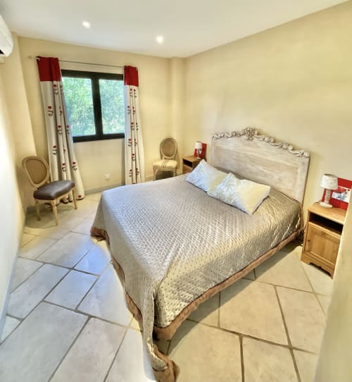 Chambre lumineuse à l'Appartement Bavella du Domaine Pero Longo à Sartène, avec lit queen-size, murs crème et accès au balcon