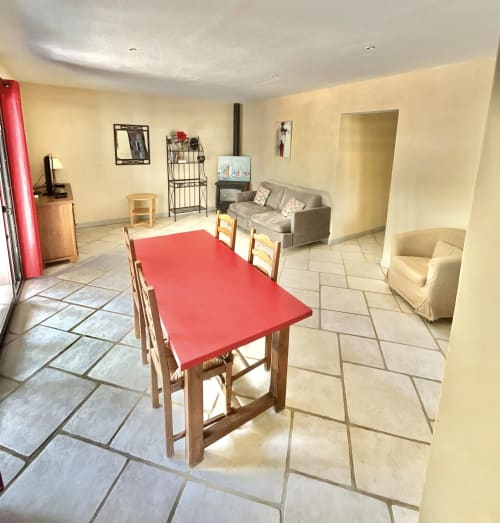 Spacieux salon-salle à manger de l'Appartement Bavella au Domaine Pero Longo, Sartène, avec table rouge et canapé gris