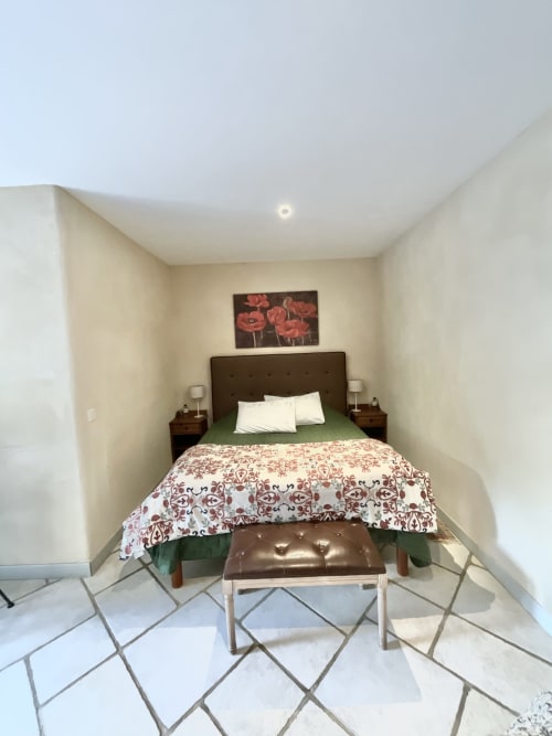 Chambre douillet du Domaine Pero Longo à Sartène, Corse : lit queen-size, décoration florale et carrelage