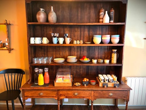 Étagère en bois présentant vaisselle, verres et objets de décoration à l'hôtel Maisons Delphine à Villers-sur-Mer