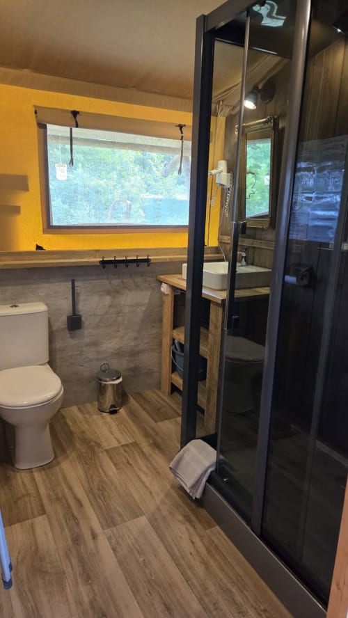 Salle de bain moderne du gîte Home Sweet Lodge avec douche, toilettes et fenêtre vue montagne près de Saint Germain et