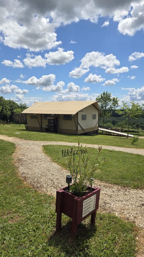 Panneau d'accueil du glamping Home Sweet Lodge en Aquitaine, avec tentes toile et vue sur les montagnes