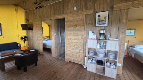 Intérieur chaleureux de chalet en bois avec kitchenette, séjour et chambres à Home Sweet Lodge Glamping Aquitaine