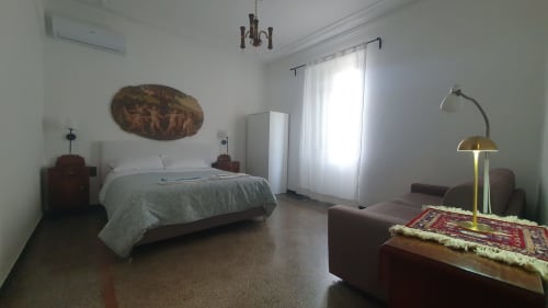 Luminosa camera degli Kate Apartments a Genova con vista sulla città, letto, armadio e zona soggiorno