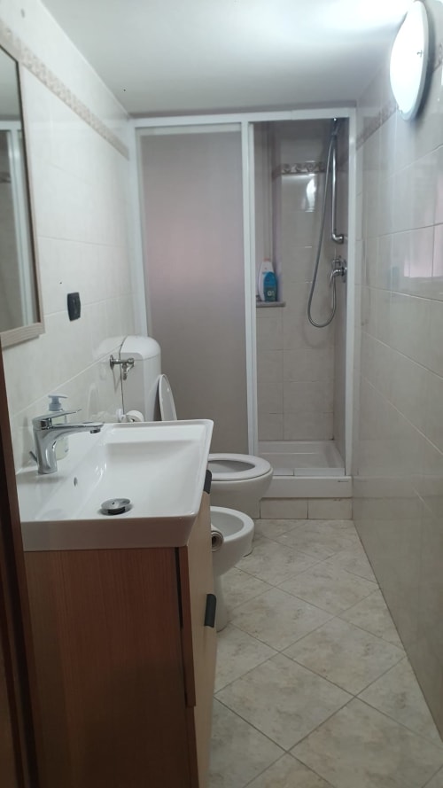 Moderno bagno presso Kate Apartments Genova con lavabo, wc, box doccia e piastrelle bianche