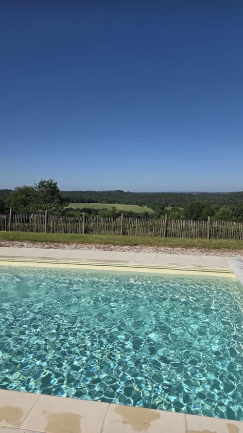 Piscine aux eaux cristallines avec vue sur la campagne verdoyante du glamping Home Sweet Lodge en Aquitaine, France