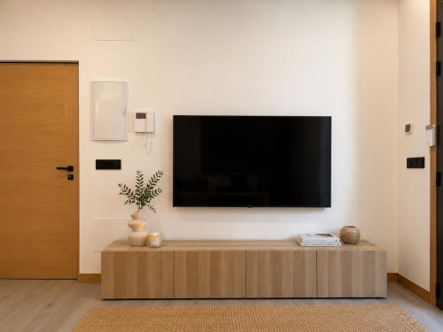 Sala moderna en Alojamientos Apoio 360 con TV mural, consola de madera y decoración minimalista