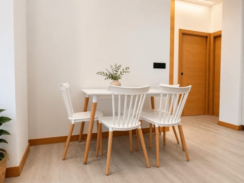 Comedor moderno en apartamento Alojamientos Apoio 360 con sillas blancas, mesa de madera y planta decorativa