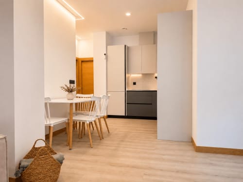 Cocina y comedor modernos con suelos de madera en el apartamento Alojamientos Apoio 360, Caldas de Reis, diseño contemporáneo