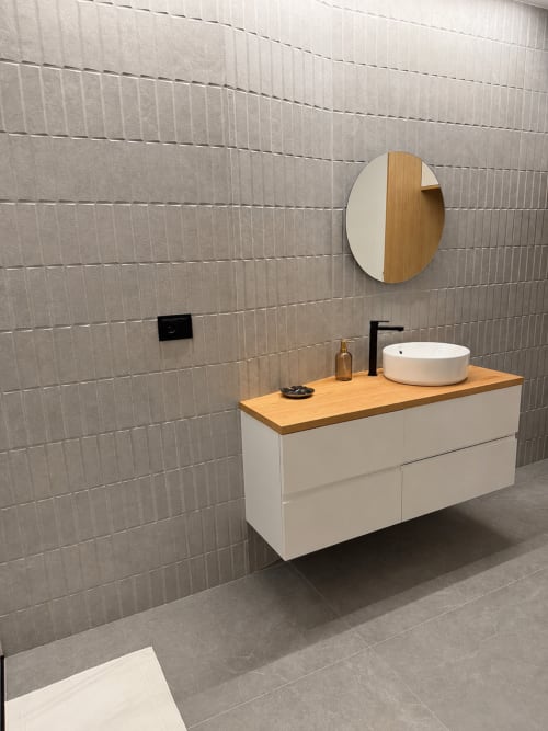 Lavabo moderno con encimera de madera, lavamanos de cerámica blanca y espejo redondo en Alojamientos Apoio 360, Caldas de Reis