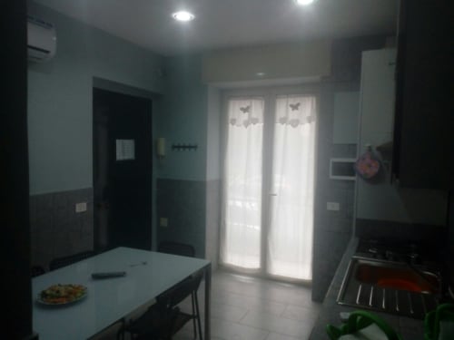Modern kitchen and dining area in Neapolis Tecnotourist apartment with contemporary finishes and natural light from glass