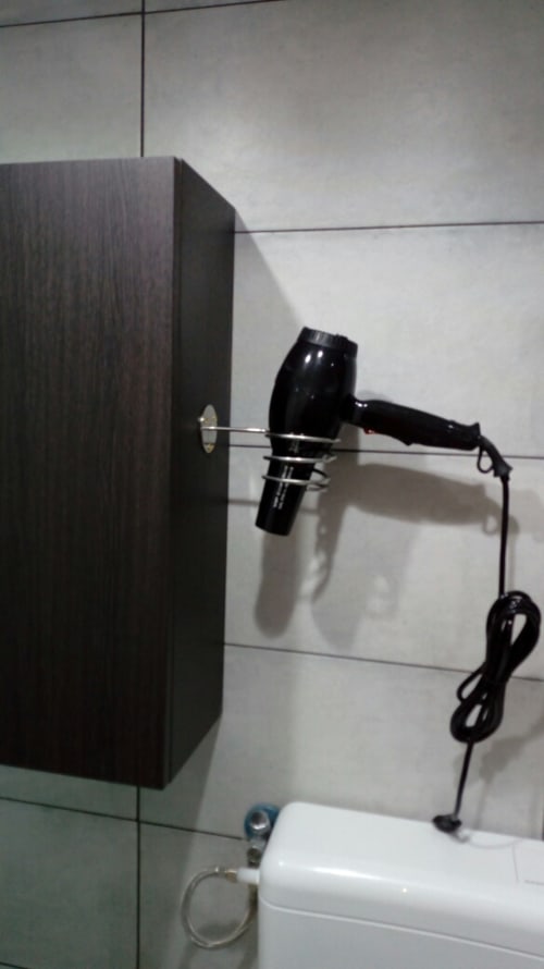 Bathroom hair dryer mounted on wall near mirror in Neapolis Tecnotourist apartment