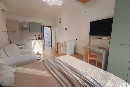 Moderno monolocale a Torre del Borgo in Valle Mosso con letto, angolo cottura, scrivania e televisione