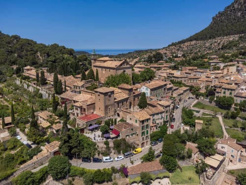 Vista aérea del hostal Villa Palmer en Paguera, España, rodeado de arquitectura mediterránea y colinas boscosas