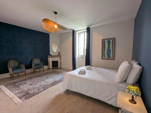 Chambre spacieuse au Domaine du Faure à Chadurie avec lit king-size, cheminée et décoration contemporaine